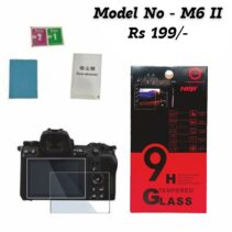 Product photo showing a 9H Tempered Glass Screen Protector kit for the Canon EOS M6 Mark II camera. The image features the glass protector placed over the camera’s LCD screen, along with the retail packaging (red and black box highlighting "9H Tempered Glass," "Ultra Slim Thickness," and "Bubble Free"), cleaning wipes, dust absorber, and microfiber cloth. The price is displayed as "Rs 199/-".