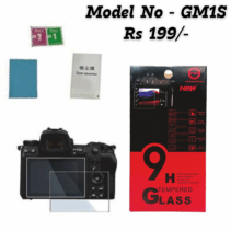 A product image showing the GM1S 9H Tempered Glass Screen Protector kit for a camera, priced at Rs 199/-. The image features a mirrorless or DSLR camera with the screen protector applied/shown next to the LCD. To the right is the red and black retail box highlighting the "9H Tempered Glass" and features like 9H Strong Hardness, Bubble Free, Self-Adsorption, Smudge Proof, and Explosion Proof. The kit components, including a microfibre cloth and cleaning wipes (labeled 1 and 2), are also visible.