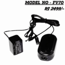 FV-70 USB Dummy Battery Charger Kit DC Coupler and AC Power Adapter shown on a white background. The image displays the black, rectangular DC Coupler (dummy battery) attached to a power brick and the separate oval-shaped AC adapter, with Model No - FV70 and the price RS 2499/- overlaid in bold, stylized text.