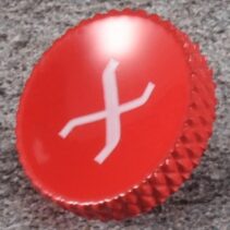 Red concave soft release shutter button made of brass with a 10mm (0.39 inch) diameter, shown next to a Fujifilm X-Series camera body.
